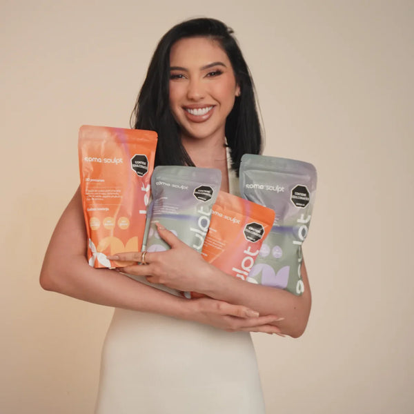 Mujer sonriente sosteniendo paquetes de SOMA Sculpt sabor naranja y piña, bebida funcional con fibra para saciedad y bienestar digestivo en rutina diaria