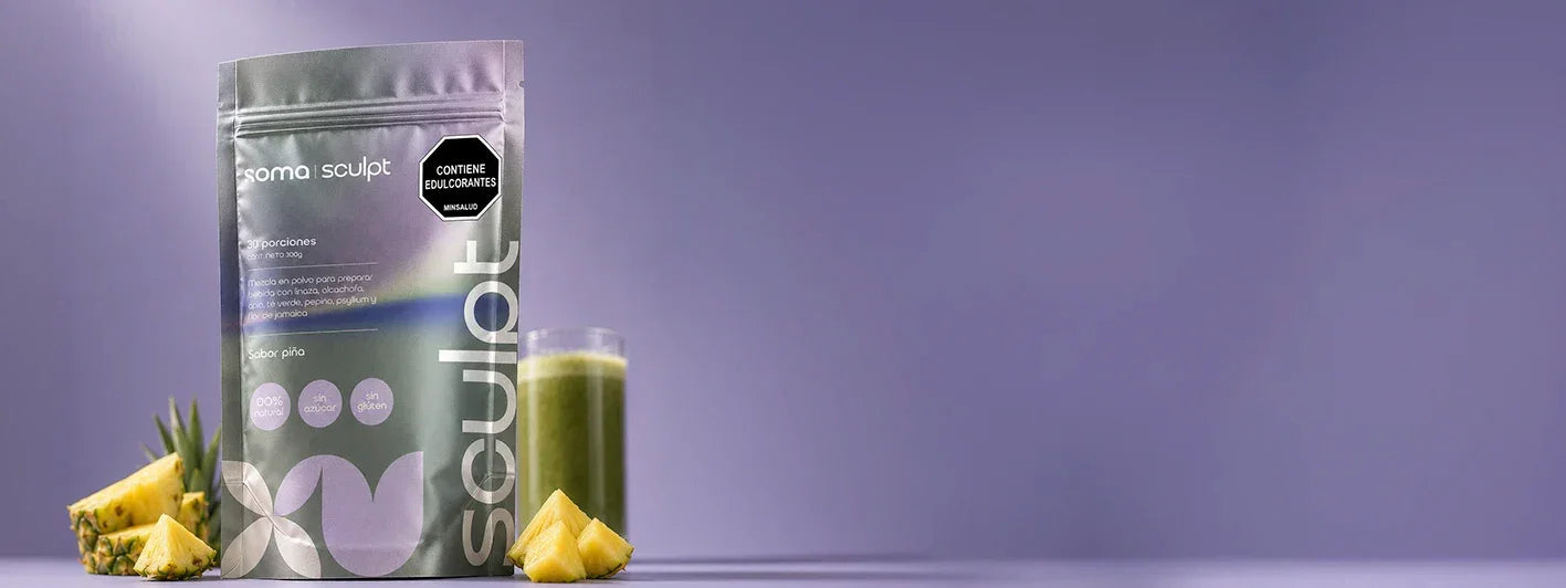 Soma Sculpt sabor piña, bebida funcional con fibra para saciedad y bienestar digestivo, en envase de 20 porciones, acompañado de piña fresca y vaso verde.