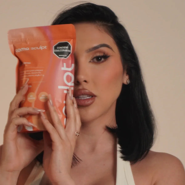 Mujer sosteniendo paquete naranja de SOMA Sculpt sabor naranja, bebida funcional con fibra para bienestar digestivo y saciedad en rutina diaria