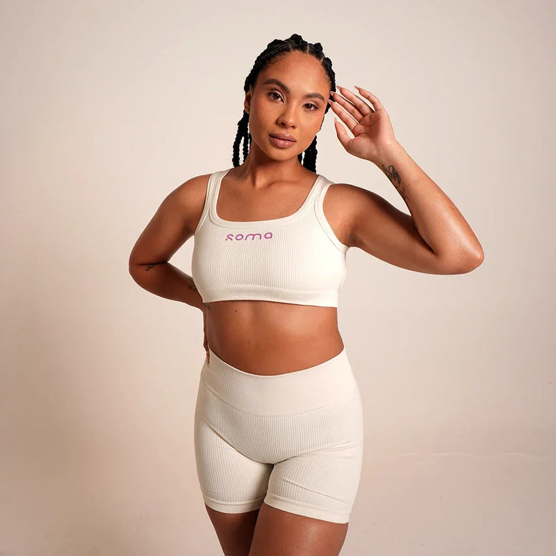 Conjunto deportivo blanco Soma con top y shorts ribeteados, ideal para yoga y entrenamiento